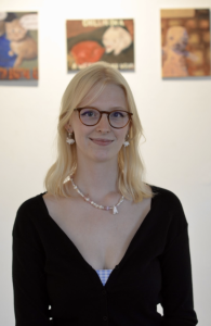 A woman with glasses, smiling. 